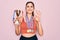 Young beautiful fitness winner athlete woman wearing sport medals and trophy doing ok sign with fingers, excellent symbol