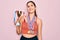 Young beautiful fitness winner athlete woman wearing sport medals and trophy with a happy face standing and smiling with a