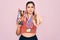 Young beautiful fitness winner athlete woman wearing sport medals and trophy pointing with finger to the camera and to you, hand