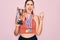 Young beautiful fitness winner athlete woman wearing sport medals and trophy screaming proud and celebrating victory and success