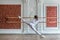 Young beautiful flexible girl in white jumpsuit is posing in a dance studio. Stretching and body ballet theme. Modern dance trend