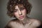 Young beautiful freckled girl with curly hair and clean makeup, selective focus