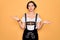 Young beautiful german woman with blue eyes wearing traditional octoberfest dress clueless and confused expression with arms and