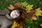 Young beautiful ginger lying on the autumn leaves