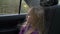 Young beautiful girl on adventure road trip inside car the wind in her hair. Pretty serious white girl. Road speed drive