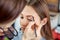 Young, beautiful girl apply makeup on a eyebrows in a beauty salon