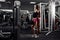 Young beautiful girl athlete bodybuilder does exercises on dark background. Concept - the power of beauty, diet, sports