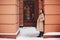 Young beautiful girl in beige coat and leather boots lonely standing outside in snowy winter weather
