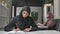 Young beautiful girl in a black hijab writes in a notebook, learns, study. Arab women in the office. 60 fps