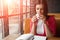 Young beautiful girl, businesswoman drinking tea or coffee sitting in cafe. Business lunch, break