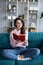 Young beautiful girl cozy on a sofa reading a book