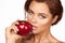 Young beautiful girl with dark curly hair, bare shoulders and neck, holding big red apple to enjoy the taste and are dieting,