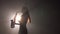 Young beautiful girl in a dark dress plays on a golden shiny saxophone on stage. Dark studio with smoke and stage