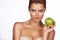 Young beautiful girl with dark hair, bare shoulders and neck, holding big green apple to enjoy the taste and are dieting, hea