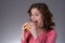 Young beautiful girl disdainfully holding a junk food from fast