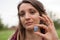 Young beautiful girl with dreadlocks holds in hand blue angelite, natural stone outdoors during a day near her face