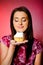 Young beautiful girl eating small sweet cake