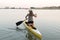 Young beautiful girl is floating on a reservoir in a canoe. The concept of sport and a healthy lifestyle