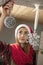 Young beautiful girl hangs Christmas decorations