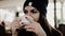 Young beautiful girl in a hat with a cup of coffee in hand and drinking it.