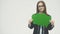 Young beautiful girl holding a green bubble for text, isolated on a white background