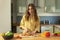 Young beautiful girl with long hair slices cherry tomatoes.