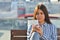 Young beautiful girl makes selfie and she is sitting on a bench in the city