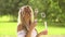 Young and beautiful girl making soap bubbles outdoors.