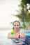 Young and beautiful girl at the pool with a cold cocktail close to her