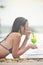 Young and beautiful girl at the pool with a cold cocktail close to her