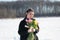 Young beautiful girl posing outside in the winter with a bouquet of tulips in a black