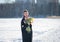 Young beautiful girl posing outside in the winter with a bouquet of tulips in a black