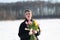 Young beautiful girl posing outside in the winter with a bouquet of tulips in a black