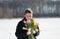 Young beautiful girl posing outside in the winter with a bouquet of tulips in a black