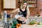 Young beautiful girl pours milk from a carafe into a glass,in the kitchen. Young woman preparinh healthy food from fresh