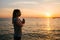 Young beautiful girl practicing yoga and meditation next to the sea at sunset. Sport. Yoga. Meditation. Recreation