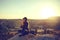 Young beautiful girl practicing yoga at the top of a mountain in Cappadocia at sunrise. Practices of relaxation.