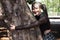 Young and beautiful girl with a punk and heavy tendency is hugging a tree in the forest. Concept of environment and love for