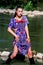 Young beautiful girl in purple dress posing in water