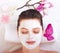 Young beautiful girl receiving pink facial mask