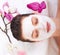 Young beautiful girl receiving pink facial mask