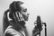 Young beautiful girl records vocals, radio, voiceover tv, reads poetry, blog, podcast in the studio on the studio microphone with