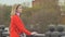 Young beautiful girl in a red coat posing on the bridge on the background Red Square, Moscow Kremlin, Russia.