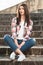 Young beautiful girl resting on the park stairs