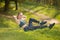 Young beautiful girl shakes press on nature on the grass