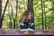 Young beautiful girl sitting in autumn park behind a wooden table reading a book