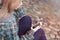 Young beautiful girl sitting on the beach and listening to music on your smartphone