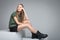 Young beautiful girl sitting on big white cube