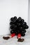 Young beautiful girl sitting in black baloons over white wall.