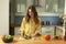 Young beautiful girl slices ripe avocado.